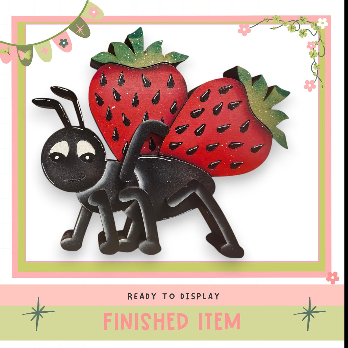 a black ant holding a red strawberry, with a pink and green border and decorative elements.