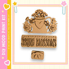 a wooden paint kit with a design that includes a heart, flowers, and the word "Spring Blossoms" written on it.
