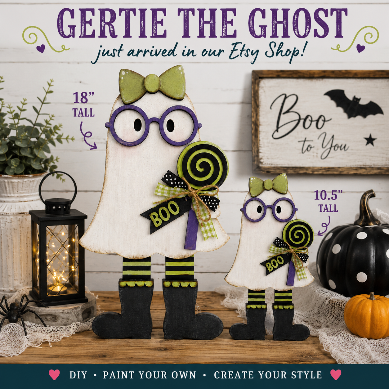 two Halloween-themed ghost figurines, one larger and one smaller, both wearing purple glasses and holding lollipops. The larger ghost has a bow on its head, and the smaller one has a bow around its neck. The scene is set against a backdrop of Halloween decorations, including a pumpkin, spider web, and a sign that says "BOO to You". The image also includes text that says "Just arrived in our Etsy Shop!" and "DIY - Paint Your Own - Create Your Style".