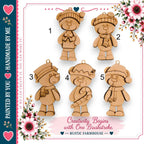 a collection of wooden teddy bear ornaments, each with a unique design and color, arranged in a visually appealing manner. The text "Creativity Begins with One Brushstroke" suggests that these ornaments can be created using a single brushstroke technique, which is a creative approach to crafting these decorative items. The image is described as a "Handmade by You" and is part of a series of handmade items, possibly for the holiday season.
