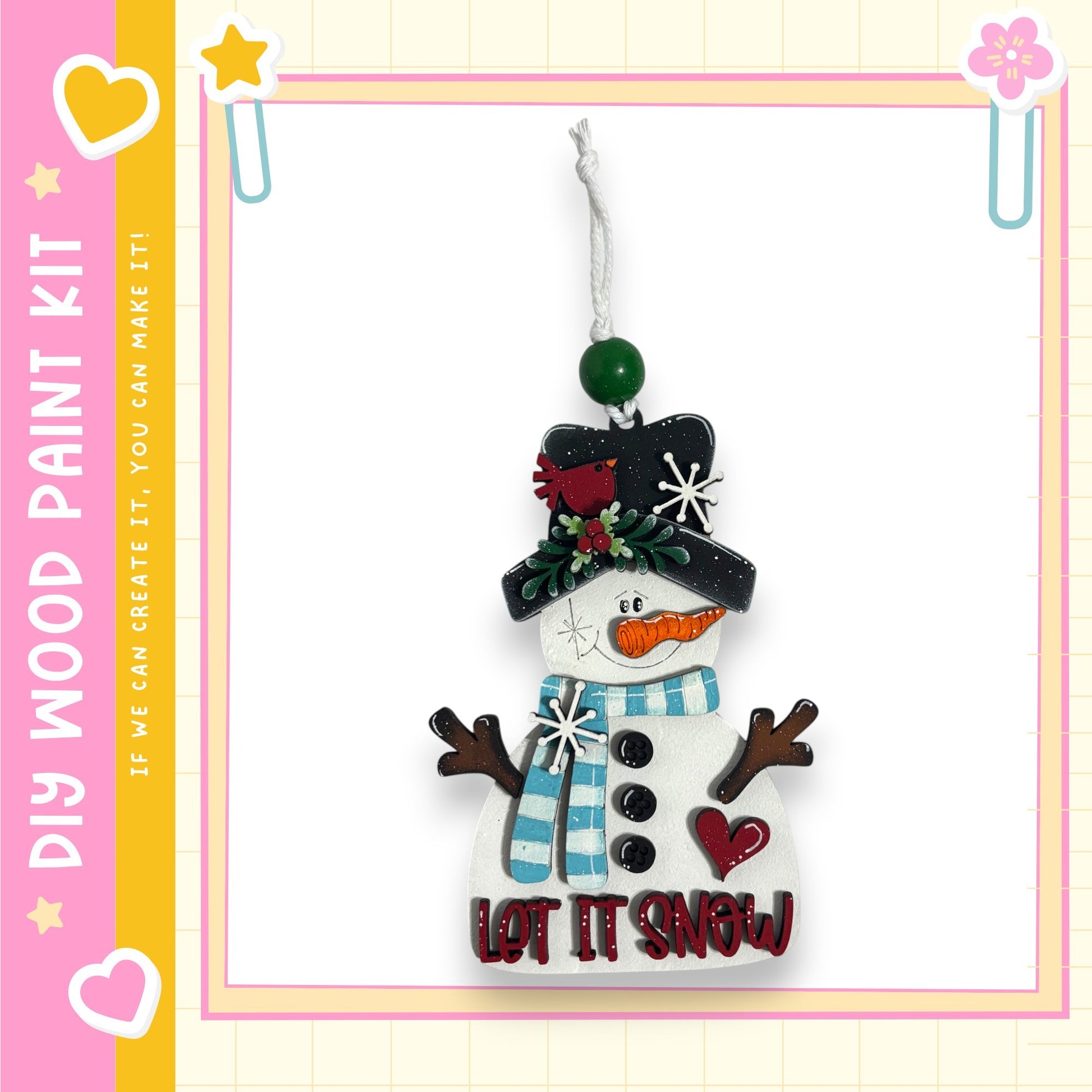 A snowman ornament with a carrot nose, coal eyes, and a scarf, hanging from a string.
