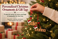 A hand holding a pair of wooden ornaments with the names "Dale" and "Donna" on them, hanging from a Christmas tree.