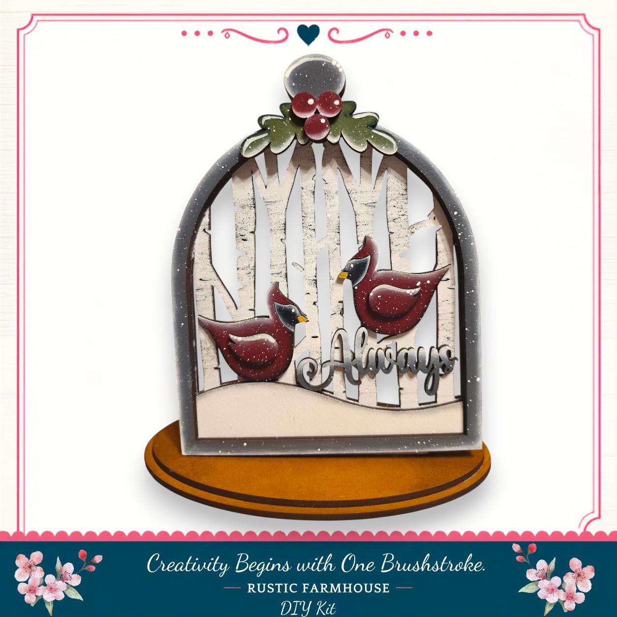 A decorative birdhouse with a snowy winter scene inside, featuring two red birds. The birdhouse is mounted on a wooden base and has a decorative border.