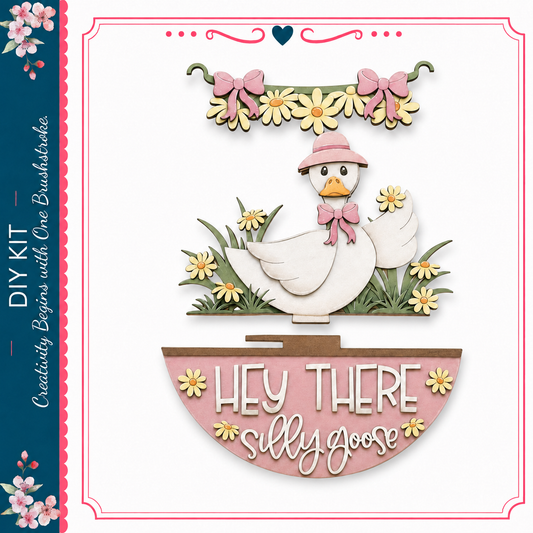 A wooden duck wearing a pink hat and bow, surrounded by flowers and grass, with the text "Hey There Silly Goose" below it.