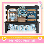 The image is a DIY wood paint kit for creating a berry-themed display, featuring a wooden sign, a wooden wagon, and a wooden pie.