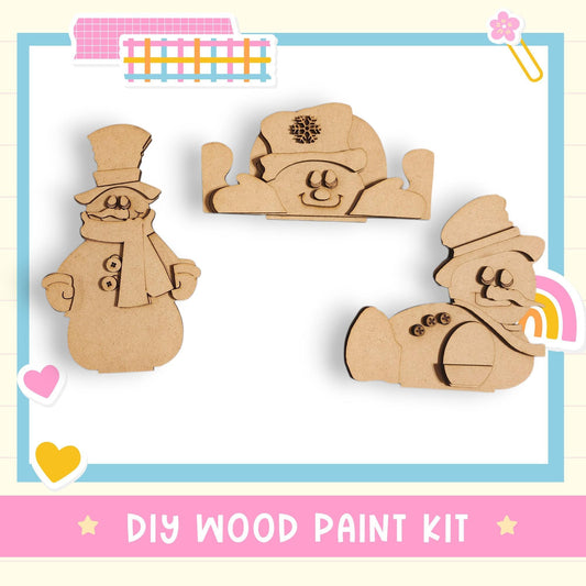 The image is a DIY wood paint kit featuring three wooden snowman or snowman-like figures made from wood.
