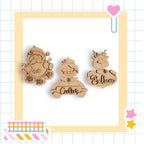 three wooden ornaments with names written on them, displayed within a decorative frame.