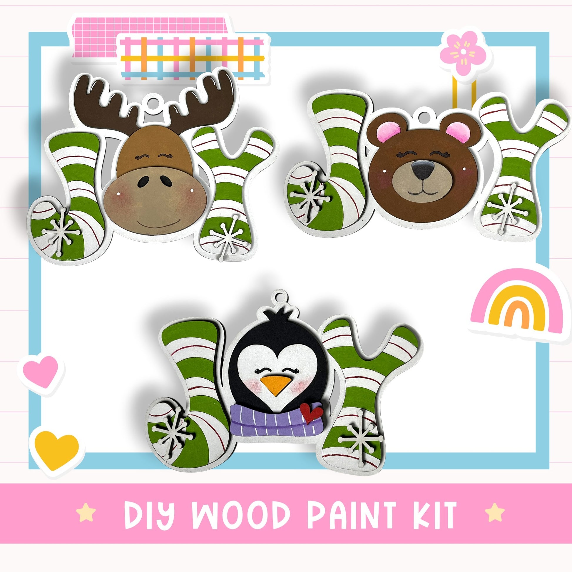 The image is a DIY wood paint kit featuring three wooden ornaments with animal faces and snowflake designs, including a moose, a bear, and a penguin.
