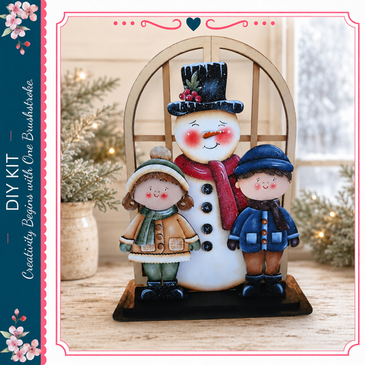 A wooden snowman figure with two children standing beside it, set against a backdrop of a window and pine trees.