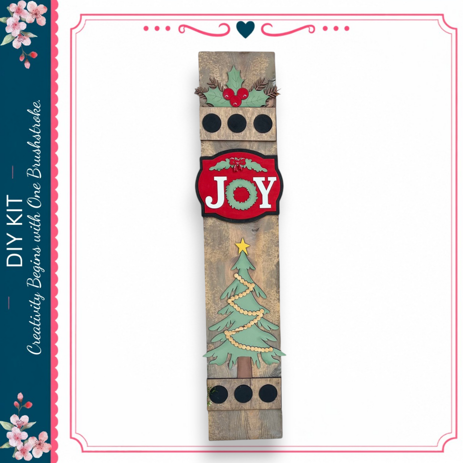 a wooden sign with a Christmas tree and the word "Joy" written on it.