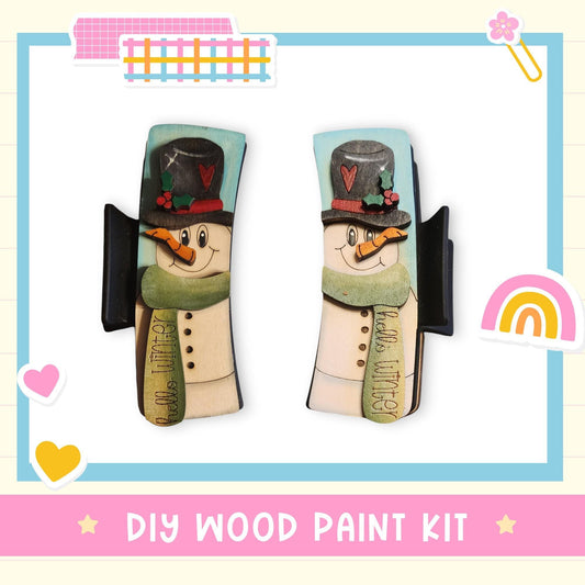 a DIY wood paint kit for creating wooden snowmen, with two snowman cutouts displayed side by side.