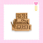 a wooden sign with the text "FRESH lavender MARKET" carved into it, set against a pink background with a scalloped edge.