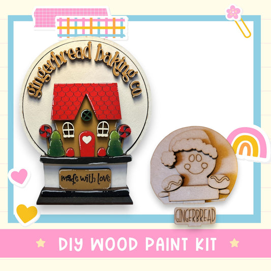 a DIY wood paint kit for creating a gingerbread house and a gingerbread cookie. The kit includes a gingerbread house and a gingerbread cookie, both made of wood and decorated with various elements such as hearts, stars, and a rainbow. The kit is designed for people who enjoy crafting and creating festive decorations.