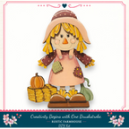 A hand-painted scarecrow figure with a pumpkin and hay bales, set against a white background with a decorative border.