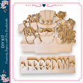 The image is a wooden craft kit featuring a patriotic design with a Santa Claus figure, fireworks, and the word "FREEDOM" prominently displayed.