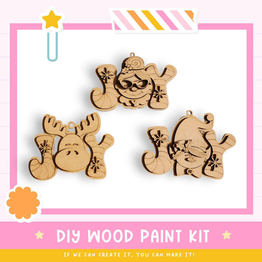 three wooden ornaments with various designs, including a moose, a snowman, and a cat, displayed against a pink background.