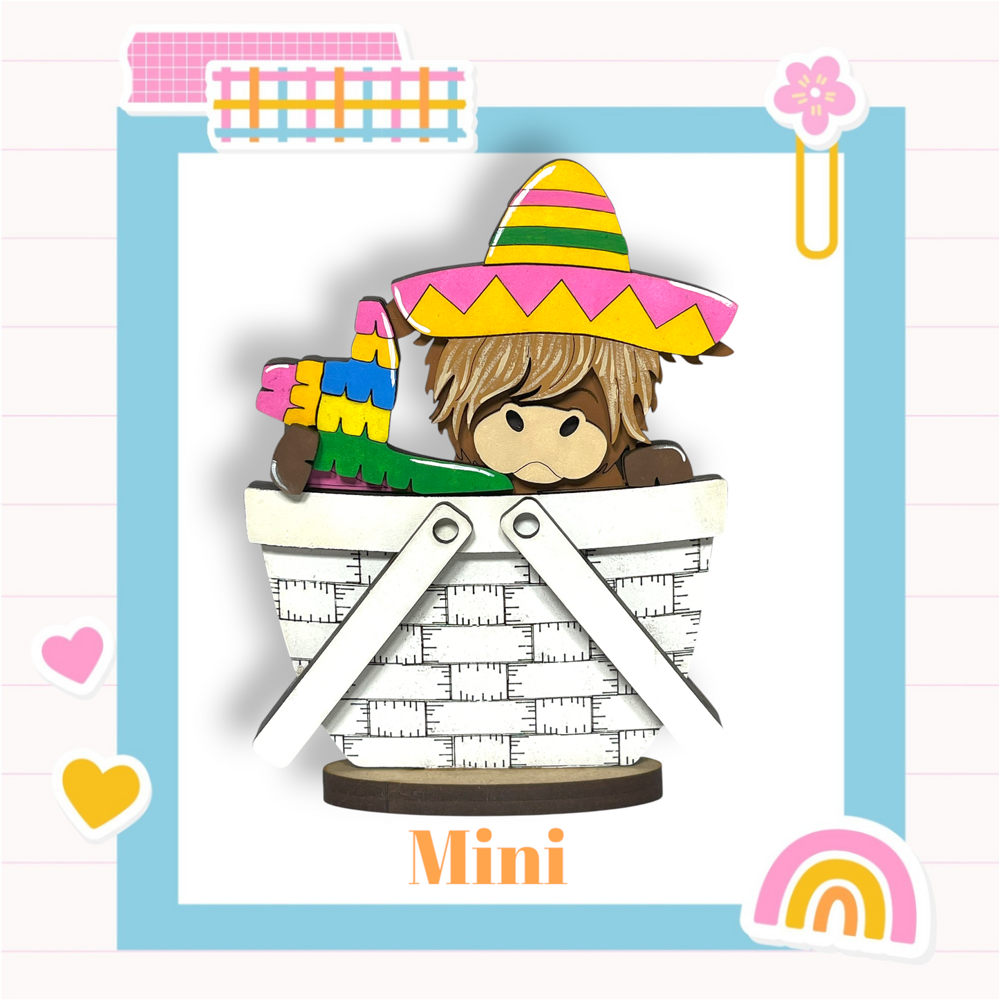 a cartoon character, a mini monkey, sitting inside a basket. The character is wearing a colorful hat and holding a toy. The image is a collage of various colorful and playful elements, including a heart, a rainbow, and a flower. The word "Mini" is also visible in the image.