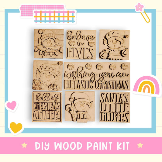 The image is a DIY wood paint kit featuring various Christmas-themed designs, including a Christmas elf, a wish you an elf, Santa Claus, and other holiday characters.