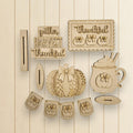 various wooden cutouts and decorations related to the Thanksgiving holiday, including a pumpkin, a mug, and a banner with the words "gather harvest thankful".