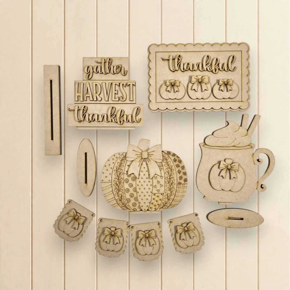 various wooden cutouts and decorations related to the Thanksgiving holiday, including a pumpkin, a mug, and a banner with the words "gather harvest thankful".
