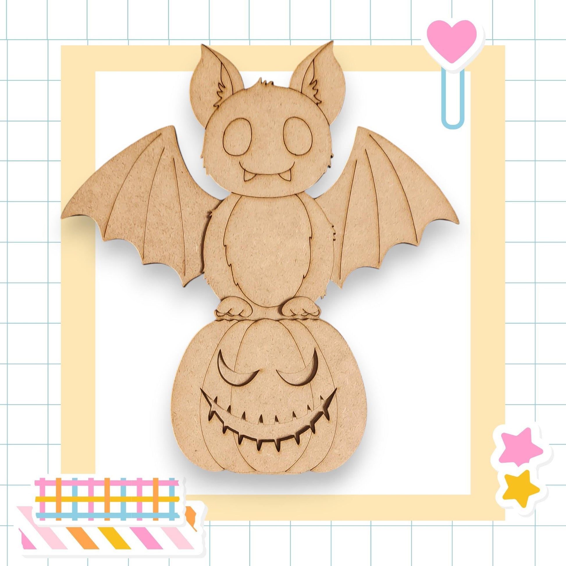 A wooden bat with a carved face is perched on a carved pumpkin, surrounded by colorful stickers and a heart-shaped object.