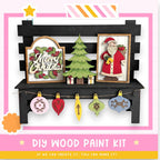 The image is a festive display featuring a Christmas-themed wooden bench with various ornaments and decorations, including a framed image of Santa Claus. The bench is adorned with a wreath, a star, and a banner with Christmas greetings. The overall scene conveys a cheerful and holiday atmosphere.