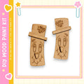 two wooden cutouts with smiling faces, set against a pink and yellow background with decorative elements.