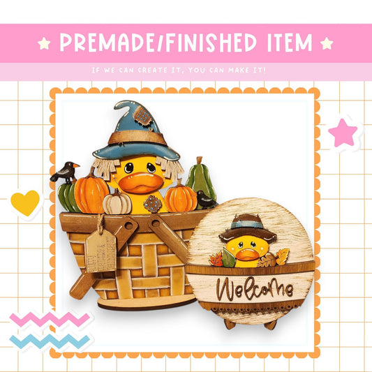 a whimsical scene with a basket containing a duck and a pumpkin, along with a sign that reads "Welcome". The duck is wearing a witch's hat, and the pumpkin is placed inside the basket. The sign is placed next to the basket, welcoming visitors to the area.