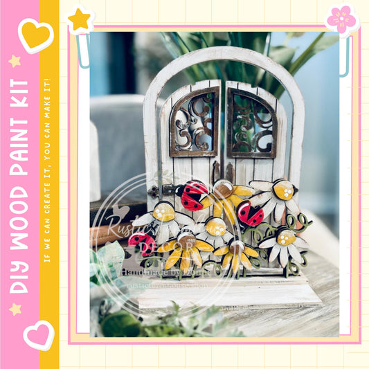A decorative wooden door with a floral design, featuring ladybugs and other flowers, is displayed on a table.