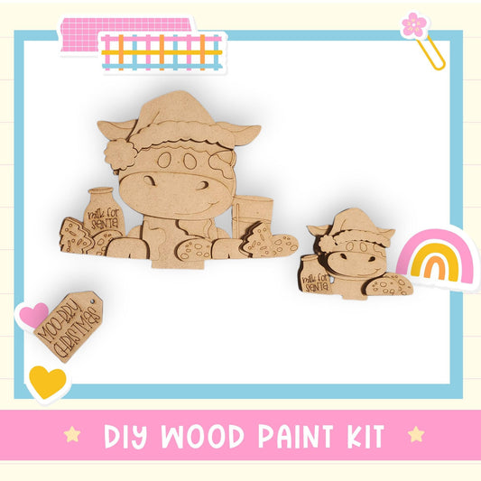 The image is a DIY wood paint kit featuring two wooden animal figures, likely cows, with various accessories and text.