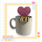 a mug with a heart-shaped sticker on it, and there is a heart-shaped sticker on top of the mug.