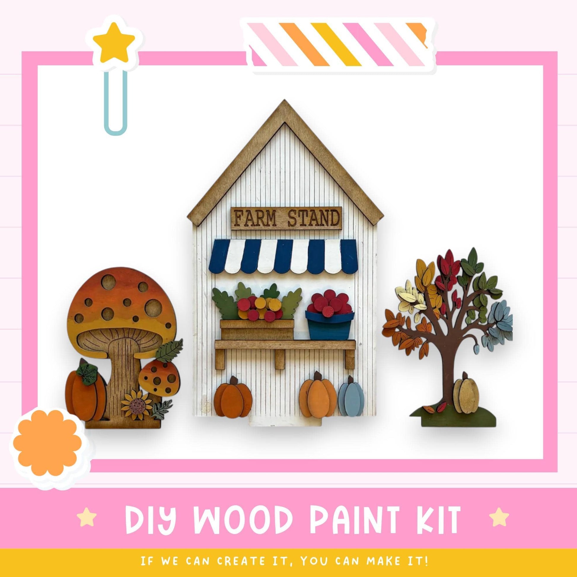 The image is a colorful and whimsical DIY wood paint kit featuring a farm stand, a mushroom, a tree, and pumpkins, all crafted from wood. The kit appears to be designed for children, as indicated by the playful and imaginative elements.