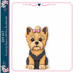 A wooden cutout of a small dog with a pink bow on its head, sitting on a white background.