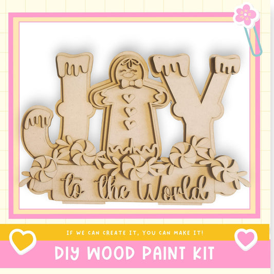The image is a DIY wood paint kit featuring a wooden gingerbread man and the phrase "to the world" written on it.