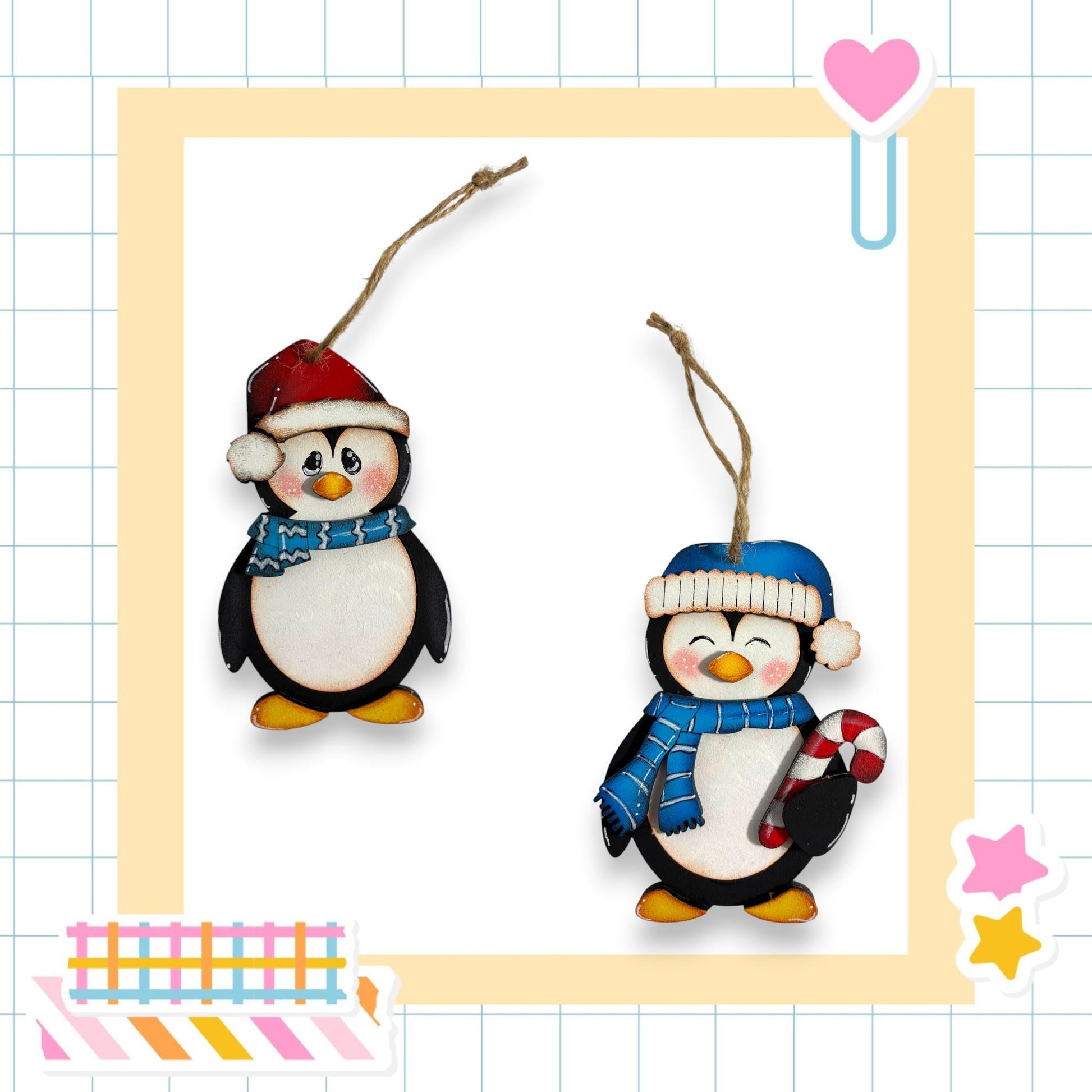 two wooden penguin ornaments hanging from strings, each wearing a hat and scarf, set against a white background with a grid pattern.