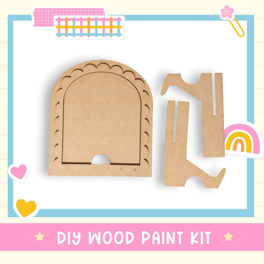 The image is a DIY wood paint kit, featuring a wooden frame and two wooden pieces, one of which is a wooden cutout. The kit is presented in a colorful and playful manner, with the text "DIY WOOD PAINT KIT" displayed prominently.