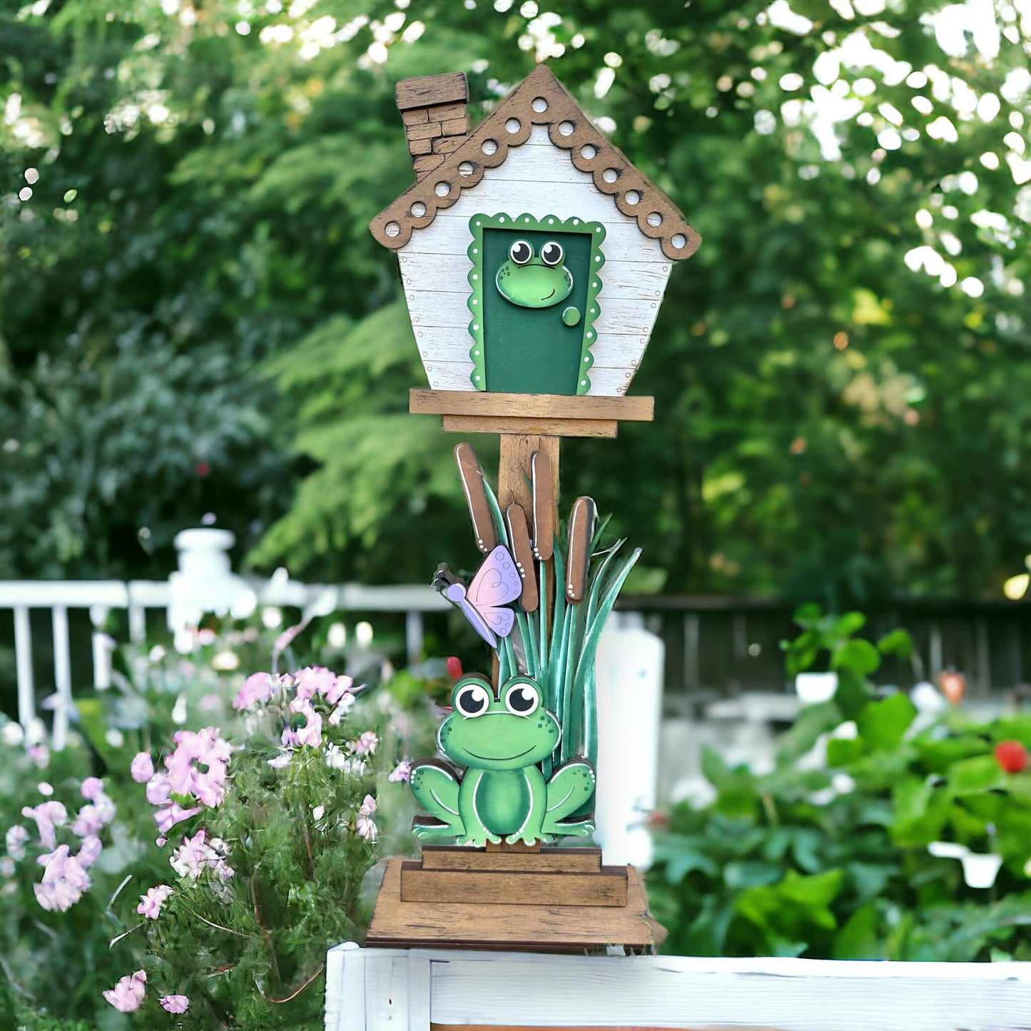 a birdhouse with a frog sitting on top of it