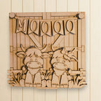 A wooden sign with a cartoon cow and the word "Moo" written on it.