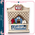 a wooden dog house with a "WOOF" sign above it, and a "Welcome" sign below. The dog house has a red fire hydrant and a green plant on it. The sign above the dog house says "WOOF", and the sign below the dog house says "Welcome". The image also includes a decorative border with pink flowers.