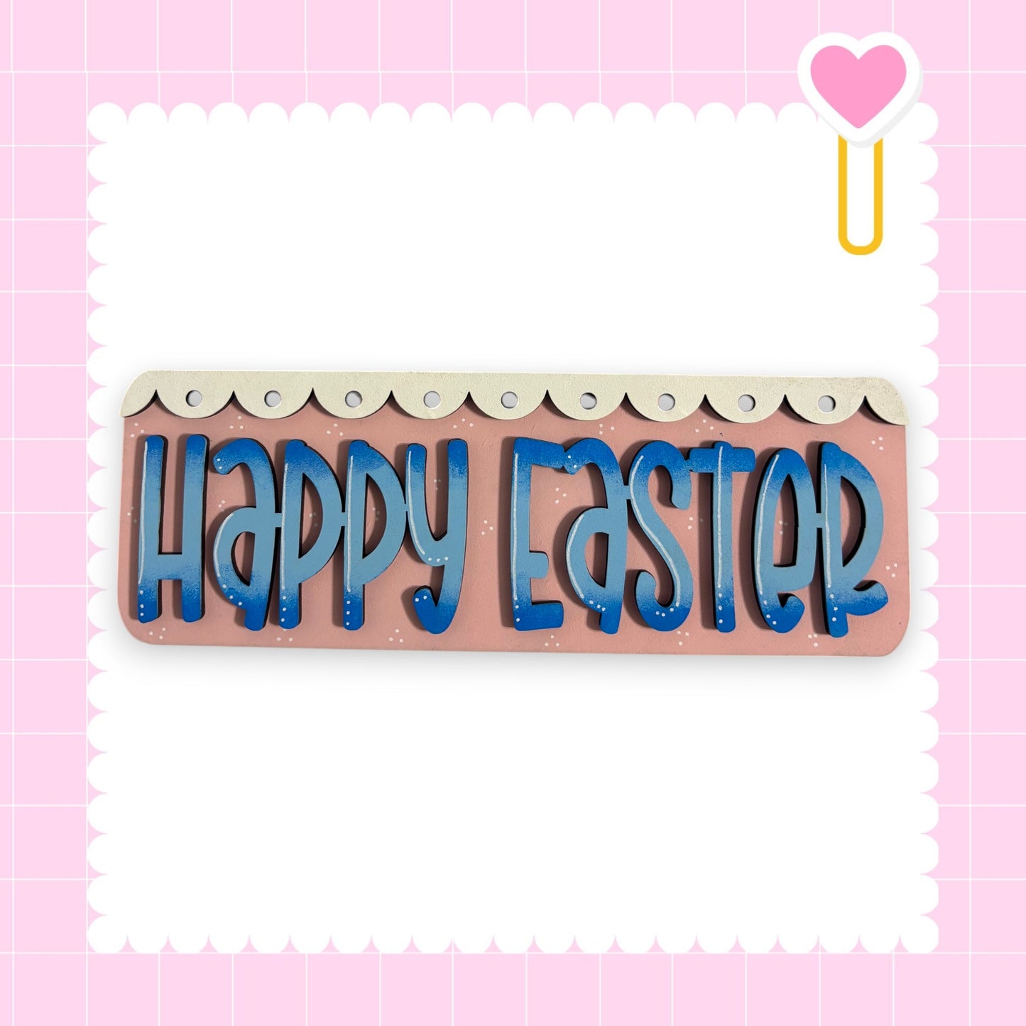 a pink background with a decorative border and a heart-shaped object on the right side. The central focus of the image is a sign that says "Happy Easter" in blue letters.