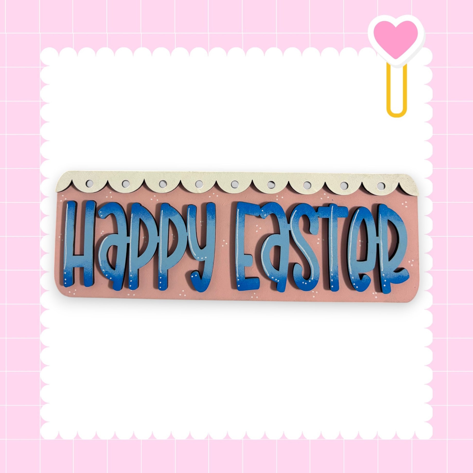 a pink background with a decorative border and a heart-shaped object on the right side. The central focus of the image is a sign that says "Happy Easter" in blue letters.
