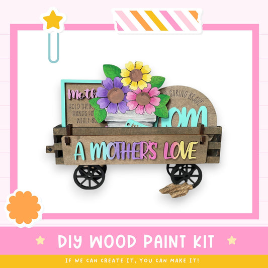 A wooden cart with a sign that says "A mother's love" and a vase of flowers, along with a star and a flower-shaped object.