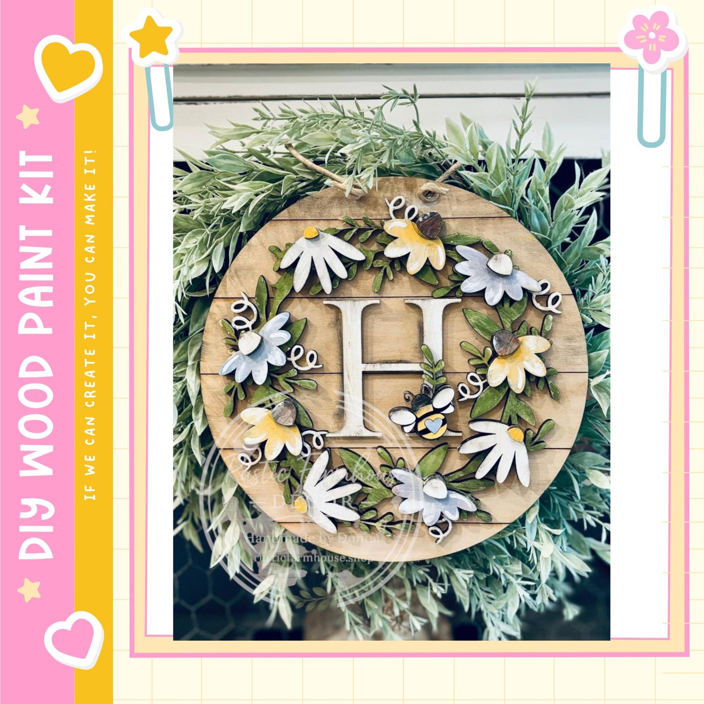 A decorative wreath made of wood and adorned with various flowers and leaves, including a large letter "H" in the center.