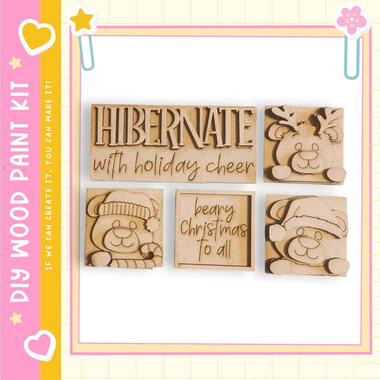 a set of four wooden cutouts, each depicting a different holiday-themed character, including a bear, a reindeer, a Christmas tree, and a Santa hat. The cutouts are arranged in a square frame, and the text "Hibernate with holiday cheer" is written above them.