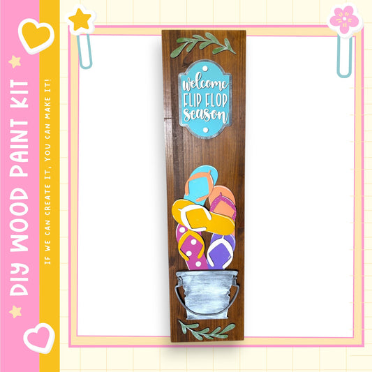a wooden sign with a welcome message and colorful flip flop designs, set against a pink and yellow background.