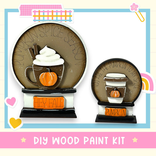 a DIY wood paint kit for creating a wooden snow globe with a pumpkin and a coffee cup. The kit includes a wooden base and a decorative pumpkin and coffee cup.