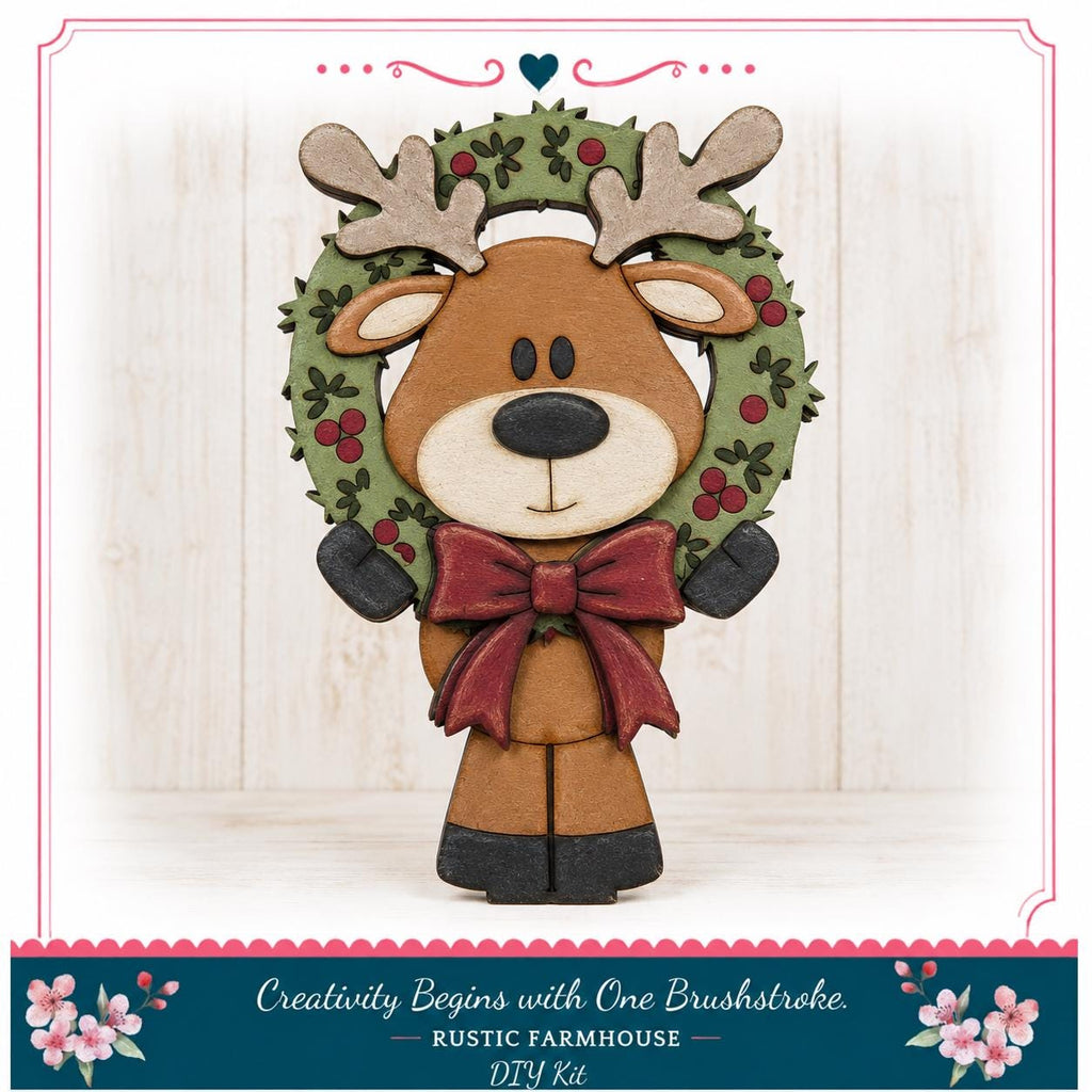 A wooden deer figure wearing a wreath and a red bow tie, standing on a wooden surface.