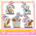 The image is a collage of five wooden Easter bunny figures, each holding a carrot and placed in a basket. The text below the image reads "DIY WOOD PAINT KIT" and "If we can create it, you can make it!"