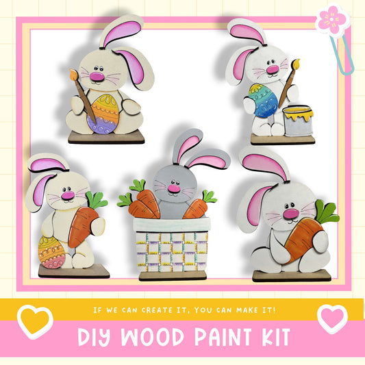 The image is a collage of five wooden Easter bunny figures, each holding a carrot and placed in a basket. The text below the image reads "DIY WOOD PAINT KIT" and "If we can create it, you can make it!"