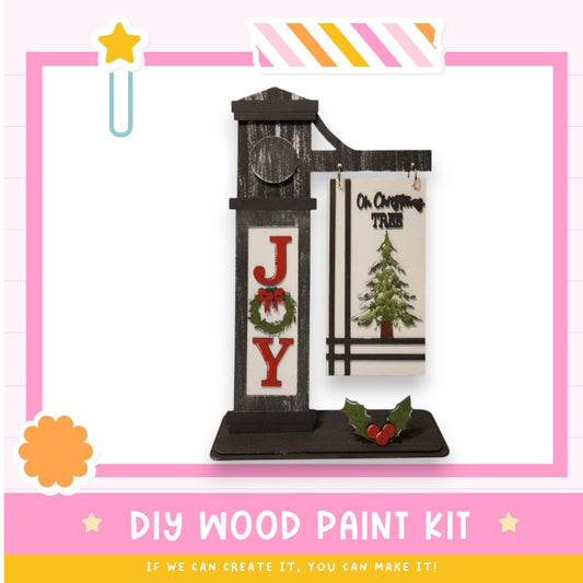 a cross stitch kit with a clock and christmas decorations